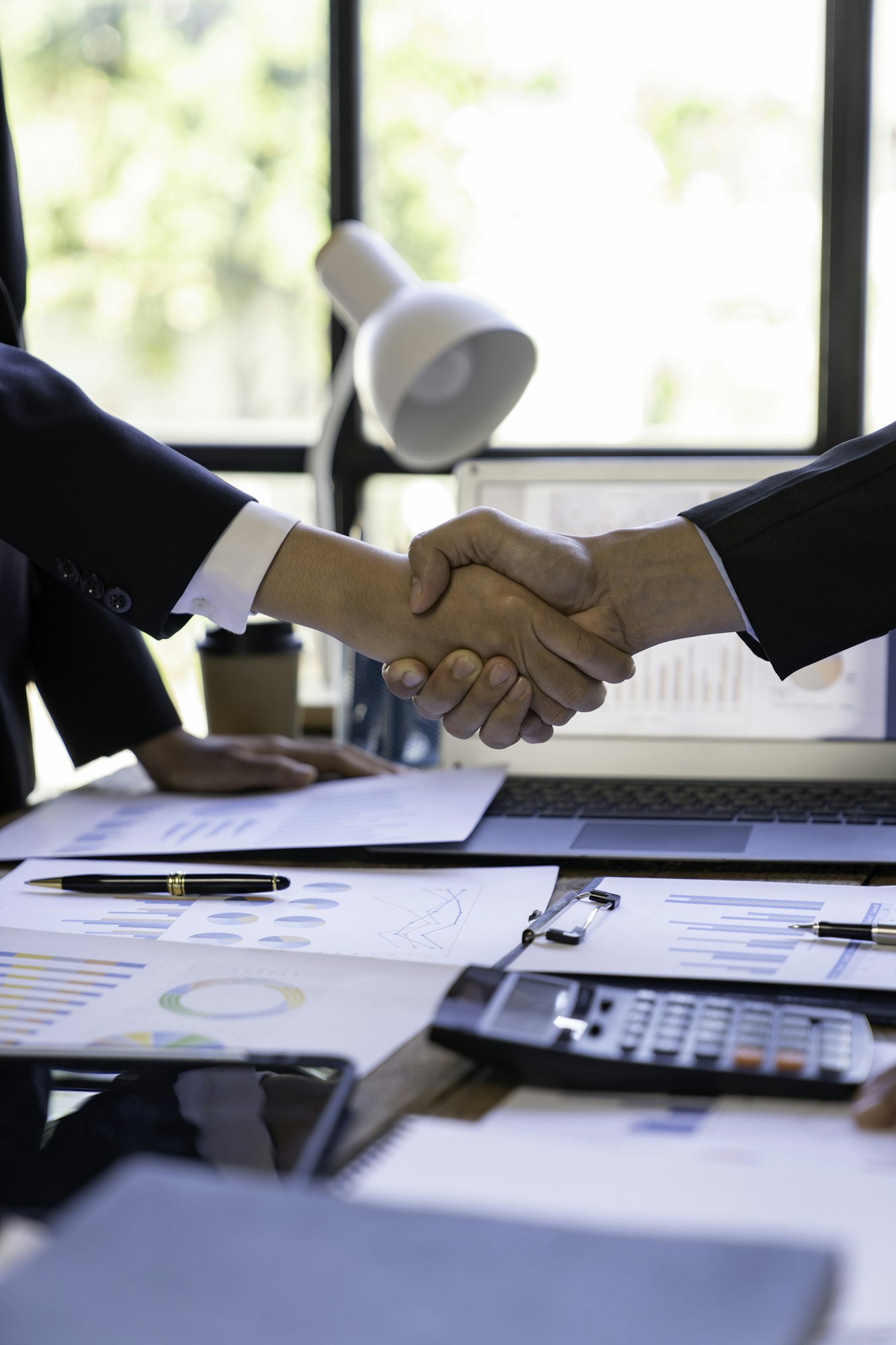 Handshake as successful negotiation ending, close-up. Unknown business people shaking hands after co